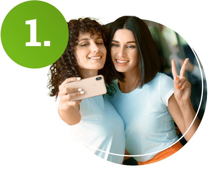 Zwei Frauen machen ein Selfie im Bus.